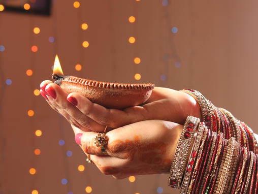 Frau hält eine Kerze für das Diwali-Fest